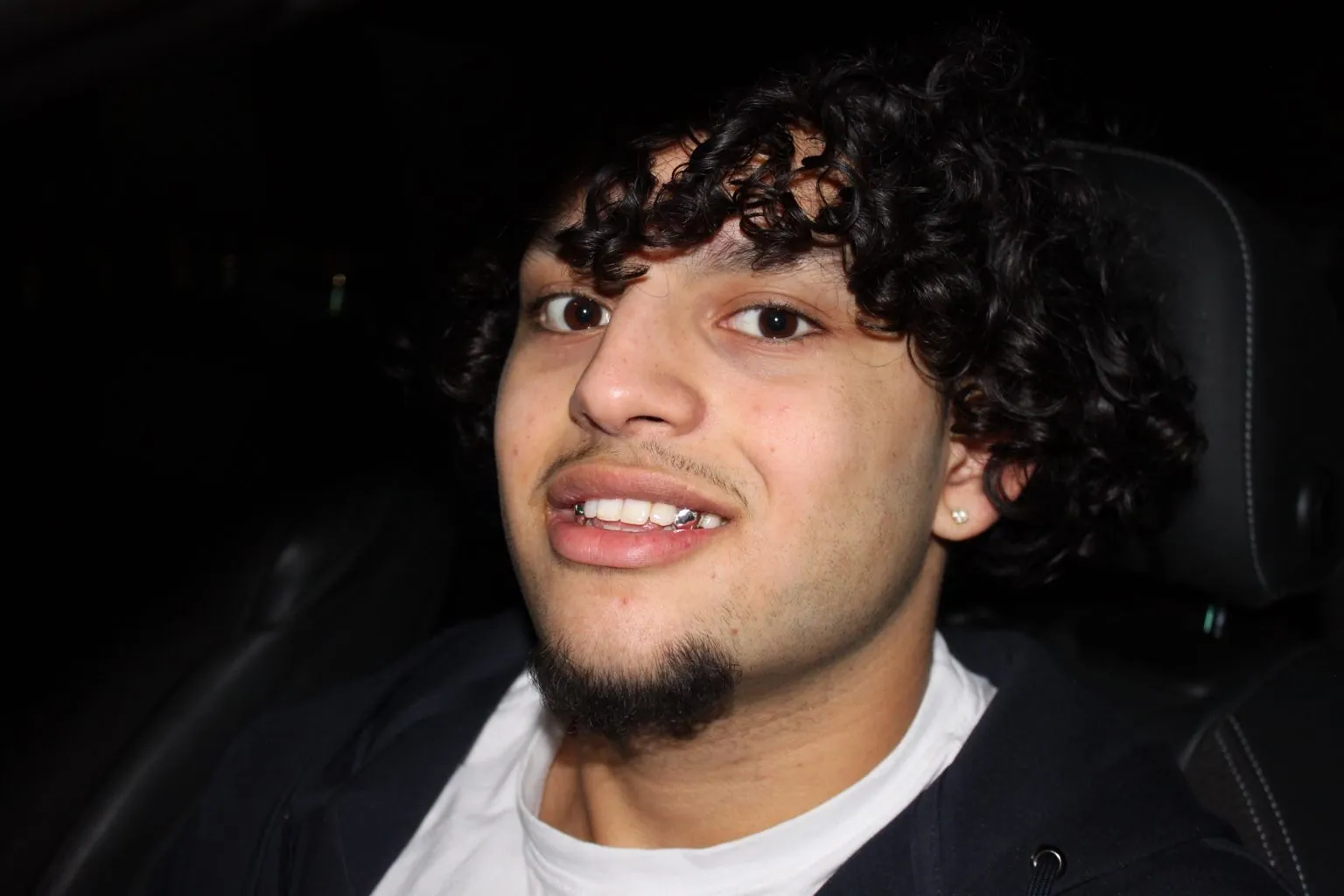 A Matrix client with curly hair smiling in a car