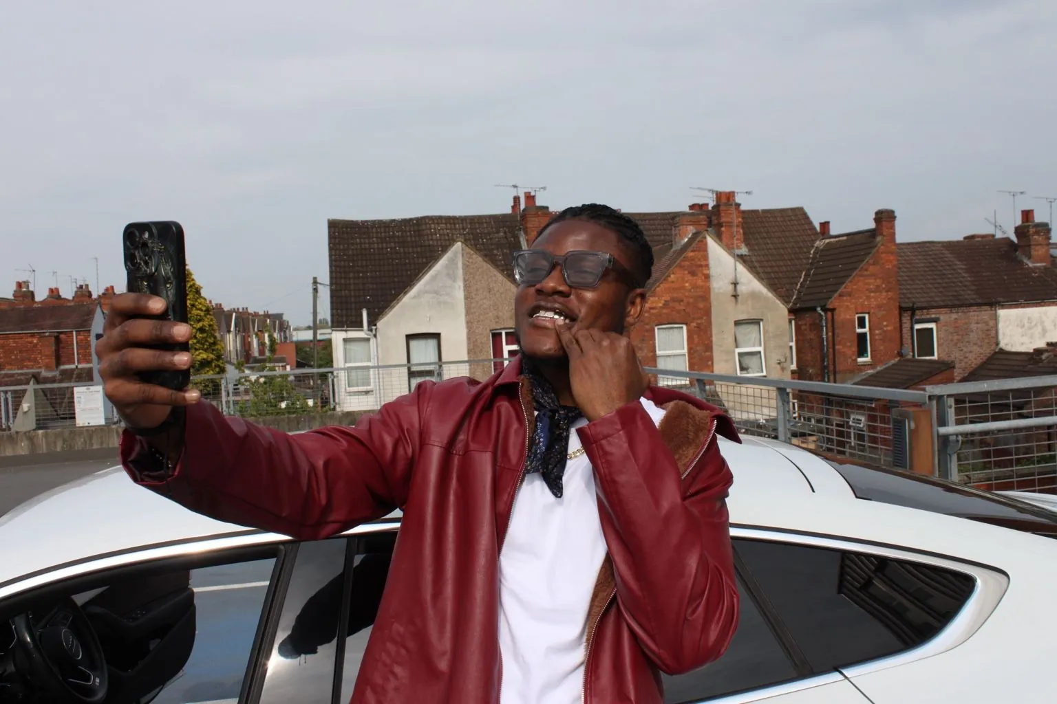 A Matrix client taking a selfie in a red jacket, showing his grillz